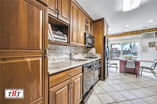 kitchen with black appliances, brown cabinetry, a sink, and decorative backsplash