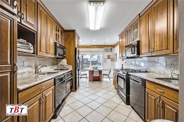 kitchen featuring light tile patterned floors, a sink, black appliances, and a wall mounted AC