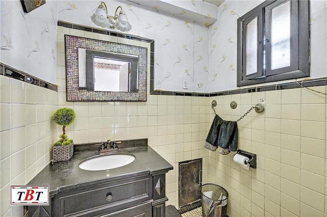 bathroom with tile walls, a wainscoted wall, and vanity