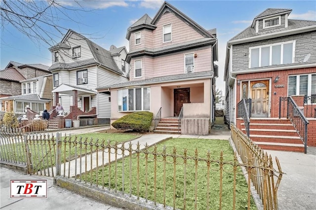 american foursquare style home featuring a fenced front yard and a front yard