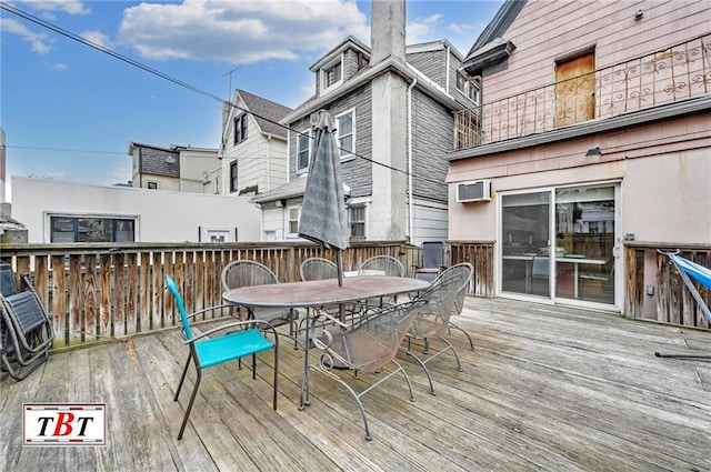 wooden terrace featuring outdoor dining space and a wall mounted air conditioner