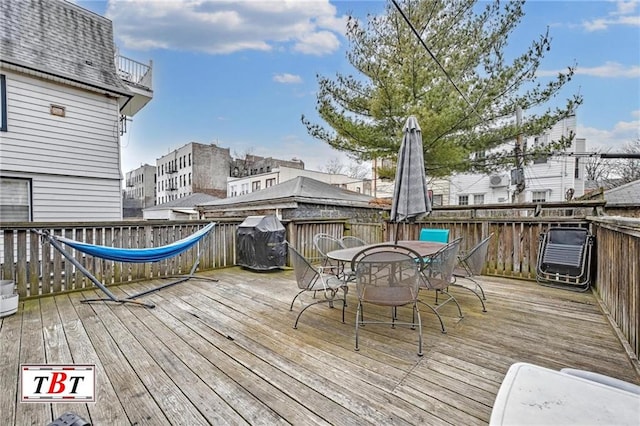 wooden terrace with outdoor dining space and area for grilling