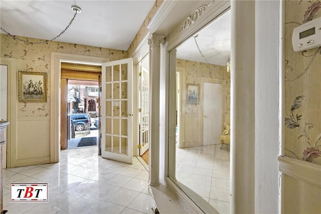 interior space featuring light tile patterned floors, wainscoting, and wallpapered walls