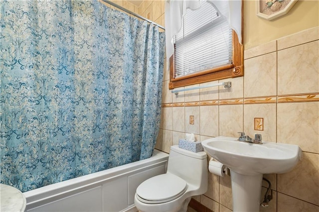 full bathroom featuring shower / tub combo, wainscoting, toilet, and tile walls