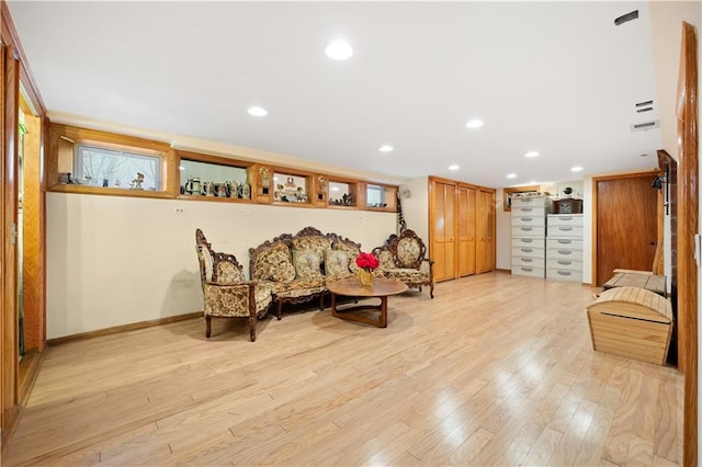 living area with light wood-type flooring, baseboards, and recessed lighting