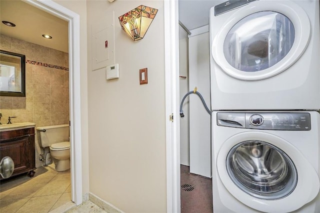 122 Prospect Park SW Unit 10, Brooklyn, NY 11218 - laundry area with estacked washer and dryer, tile walls, light tile patterned flooring, and recessed lighting