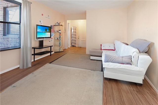 living area featuring stairway, baseboards, and wood finished floors