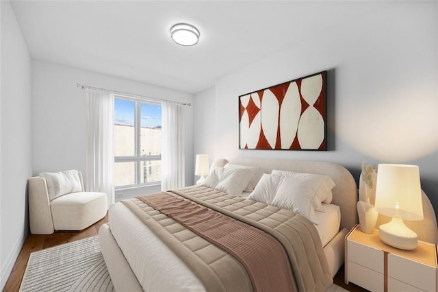 bedroom with wood finished floors and baseboards