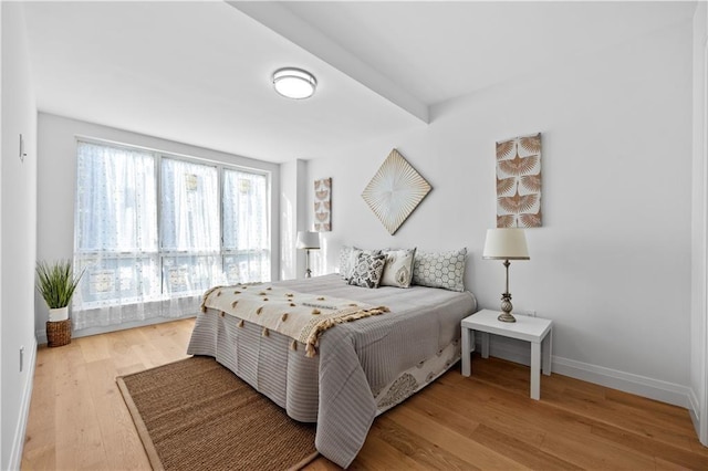 bedroom with baseboards and wood finished floors