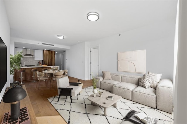 living area with visible vents and wood finished floors