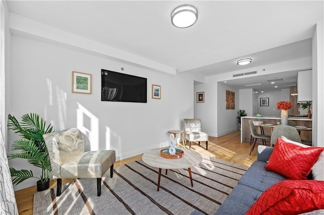 living room featuring baseboards, visible vents, and light wood-style floors