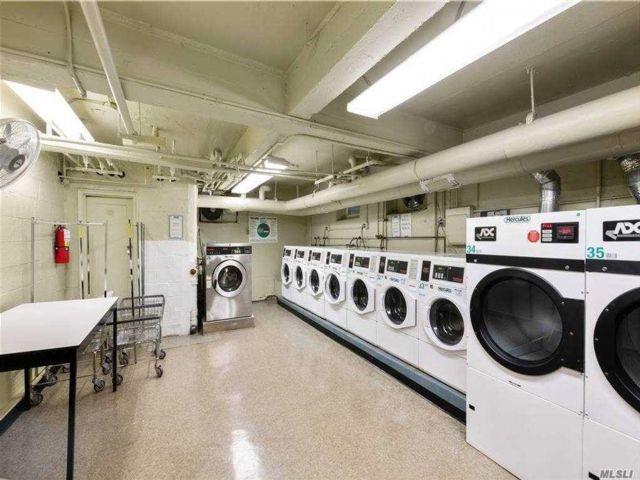 shared laundry area featuring concrete block wall and washing machine and clothes dryer