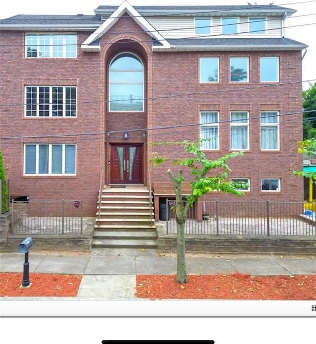 view of front of property featuring brick siding and fence