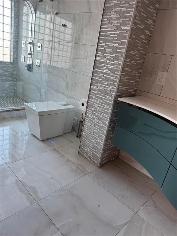 full bathroom featuring a shower stall, tile walls, and marble finish floor