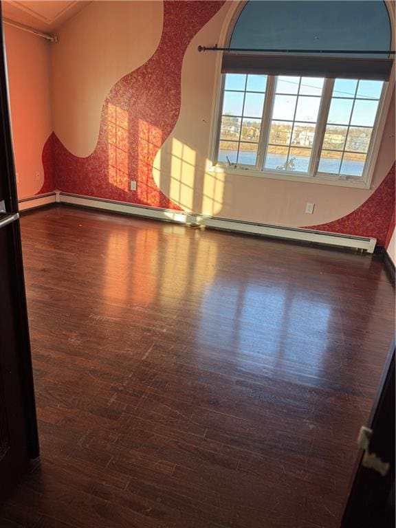 unfurnished room featuring baseboards, a healthy amount of sunlight, and wood finished floors