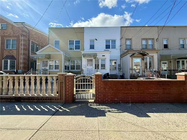 multi unit property featuring a fenced front yard and a gate