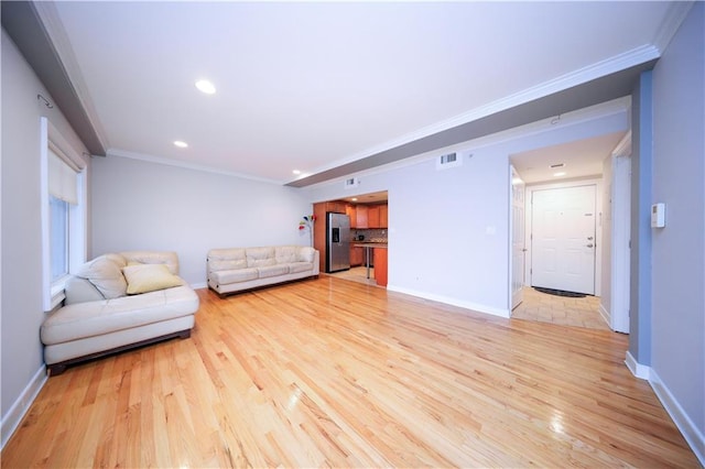 living area featuring light wood finished floors, baseboards, visible vents, crown molding, and recessed lighting