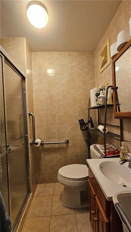 bathroom featuring tile walls, a stall shower, vanity, and tile patterned flooring