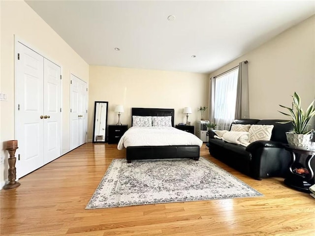 bedroom with two closets and light wood-style floors