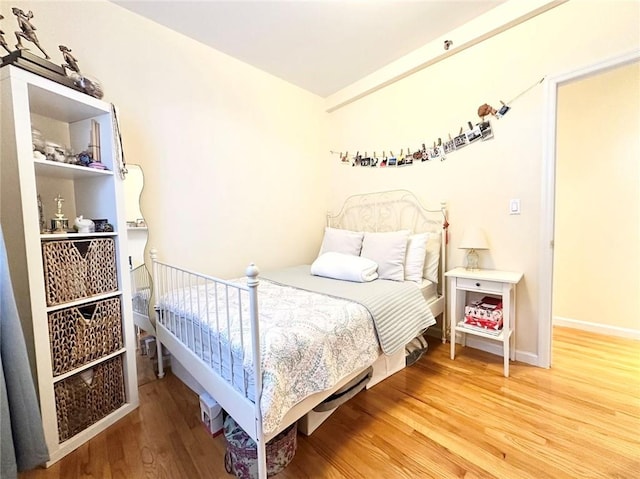 bedroom with wood finished floors and baseboards