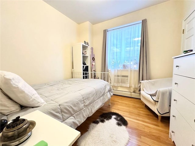 bedroom featuring a baseboard radiator and wood finished floors