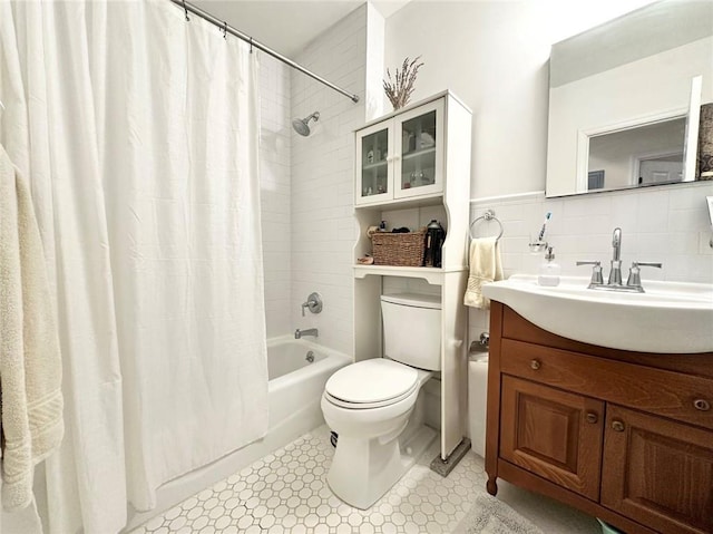 bathroom featuring toilet, shower / bath combo, tile walls, and vanity