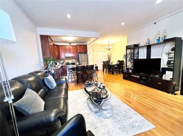 living area featuring a chandelier, recessed lighting, and light wood-style flooring