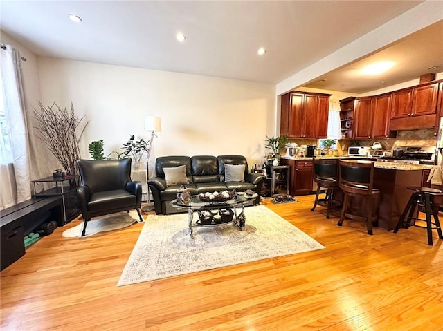 living area featuring a wealth of natural light, light wood-style flooring, and recessed lighting