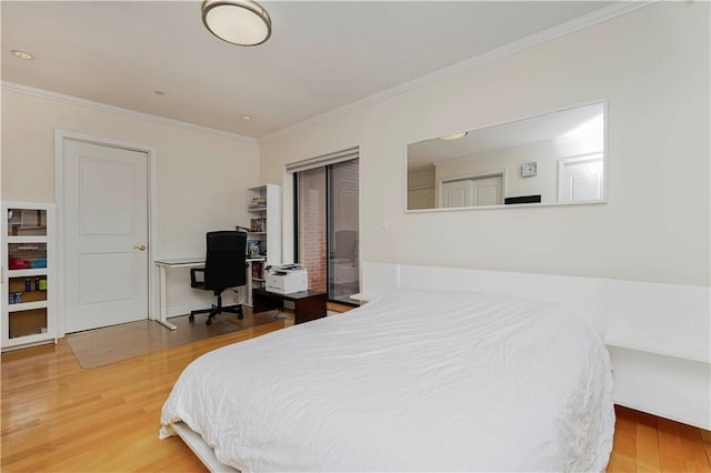 bedroom with ornamental molding and wood finished floors