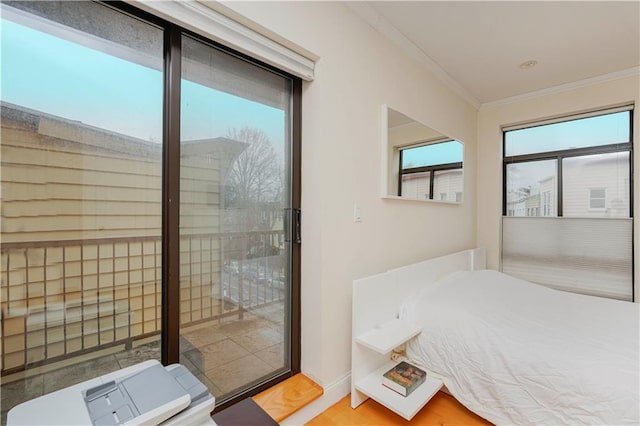 bedroom featuring ornamental molding, wood finished floors, and baseboards