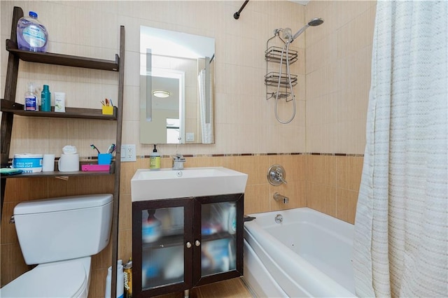 bathroom with toilet, shower / bath combo, vanity, and tile walls