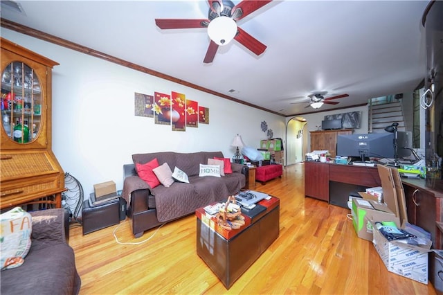 living room featuring visible vents, arched walkways, a ceiling fan, wood finished floors, and crown molding