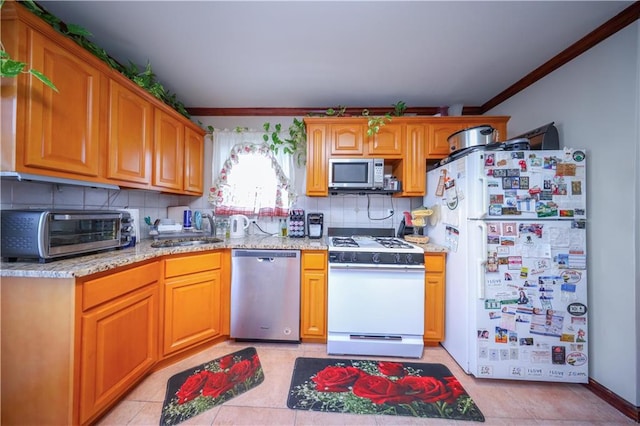 kitchen with light tile patterned floors, a toaster, a sink, stainless steel appliances, and backsplash