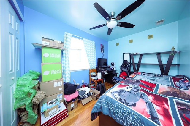 bedroom with visible vents, ceiling fan, and wood finished floors