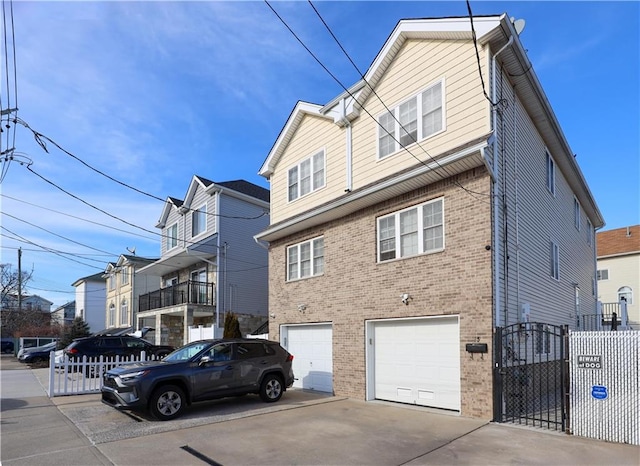 exterior space with brick siding, driveway, an attached garage, and fence