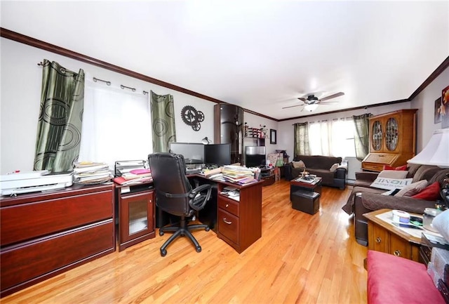 office space with ornamental molding, light wood-style flooring, and a ceiling fan