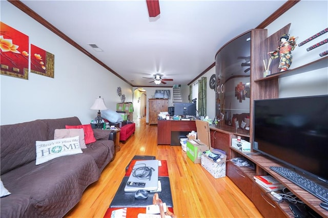 living area featuring arched walkways, visible vents, a ceiling fan, ornamental molding, and wood finished floors