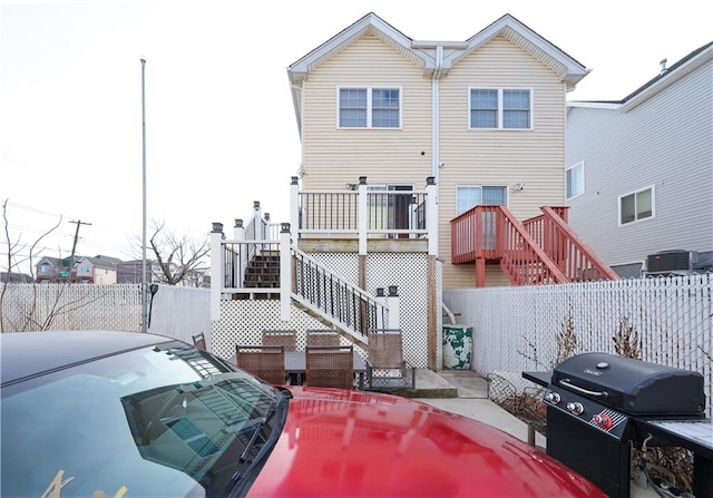 rear view of house featuring stairway, fence, and a wooden deck