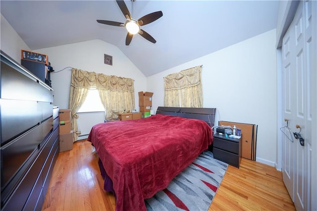 bedroom featuring vaulted ceiling, a closet, a ceiling fan, and light wood-style floors