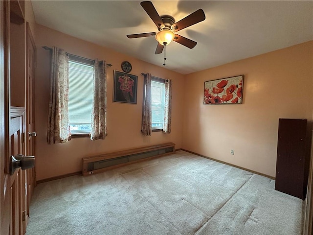 spare room with carpet floors, plenty of natural light, a baseboard radiator, and baseboards