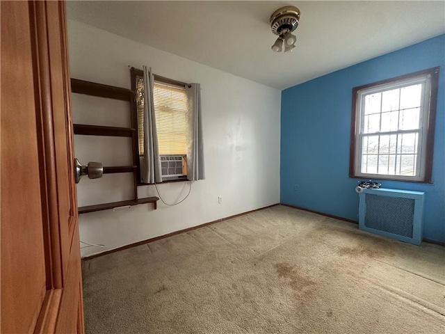 unfurnished room with carpet, radiator, cooling unit, and baseboards