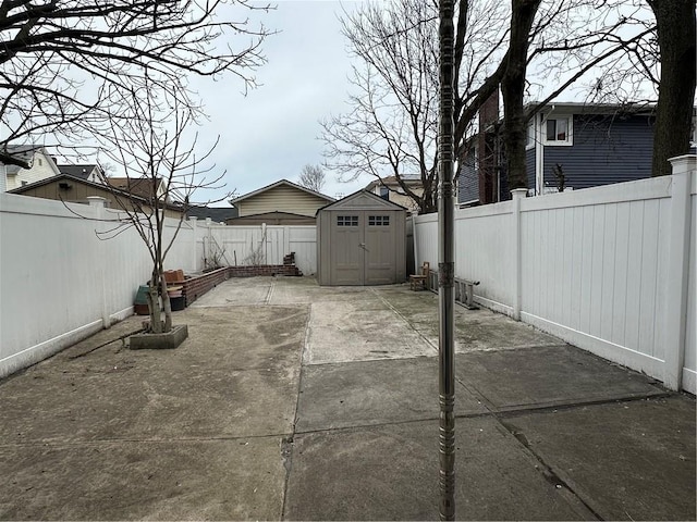 view of patio with an outbuilding, a fenced backyard, and a storage shed