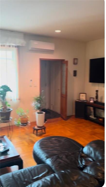 living area featuring a wall mounted air conditioner and wood finished floors