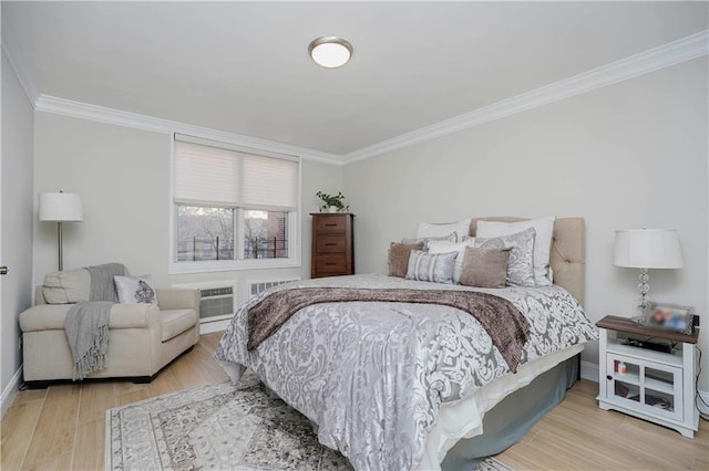 bedroom featuring a wall mounted AC, baseboards, crown molding, and wood finished floors