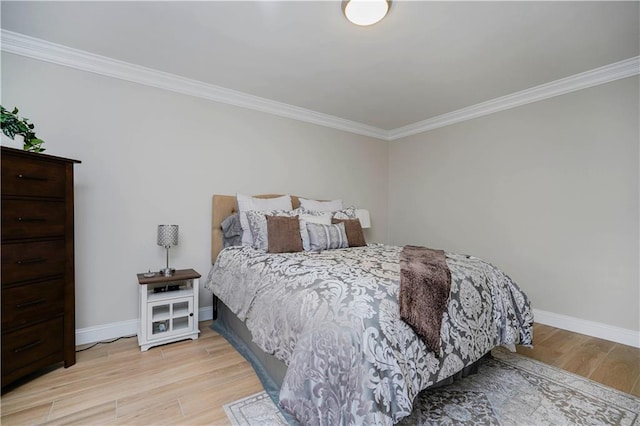 bedroom featuring ornamental molding, wood finished floors, and baseboards