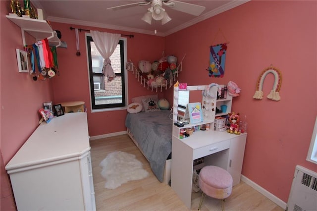 bedroom with radiator, baseboards, light wood-style floors, and ornamental molding