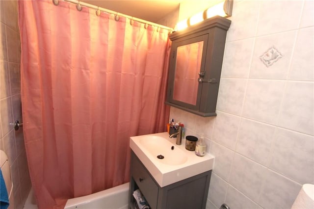 bathroom featuring vanity and tile walls