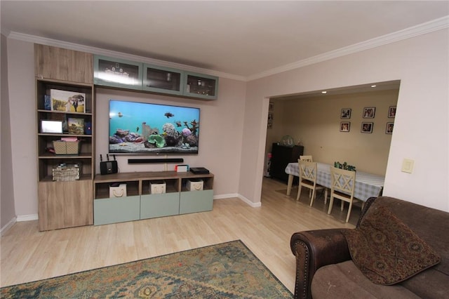 living room featuring crown molding, baseboards, and wood finished floors