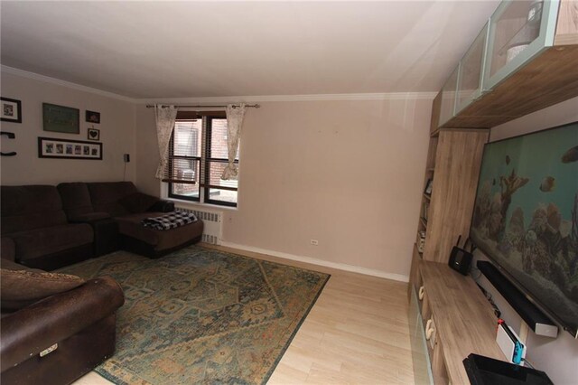 living area with crown molding, radiator, wood finished floors, and baseboards