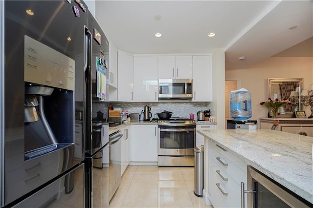 kitchen with light tile patterned floors, stainless steel appliances, wine cooler, white cabinets, and tasteful backsplash